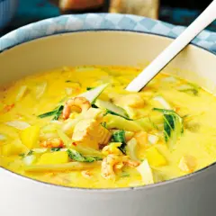 En krämig fisksoppa med saffran, räkor och lax i en vit gryta.