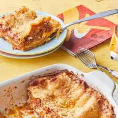Lasagne maison : une part de recette lasagne ricotta viande hachée sur une assiette, le plat encore plein à côté.