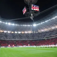 Stadion Narodowy w Warszawie, z pełną widownią, która tworzy biało-czerwony wzór. Jego imponująca pojemność robi wrażenie.