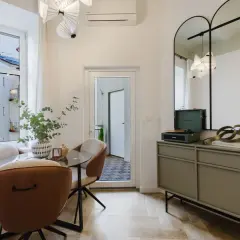 Eleganckie lustra w stylu retro nad komodą z gramofonem i książkami.