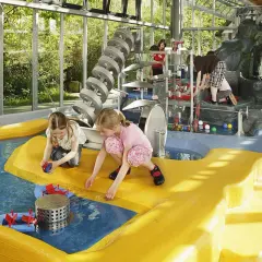 Kinder spielen im Wasserbereich des vier Jahreszeiten Parks Oelde mit bunten Bällen und Wasserrädern.