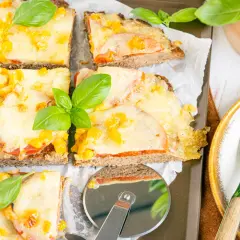 Herzhafte hackfleischpizza vom blech, Landfrauen-Art, mit Tomaten und Käse überbacken, garniert mit frischem Basilikum.