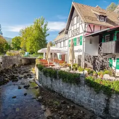 Urokliwy deptak w Szklarskiej Porębie nad górskim potokiem. Restauracja z ogródkiem i zielonymi okiennicami.
