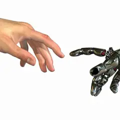 Ludzka dłoń i mechaniczna ręka zbliżają się do siebie, niemal dotykając. To symboliczny touche między człowiekiem a technologią.