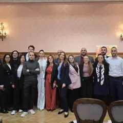 Gruppo di persone posa davanti a uno striscione della Fondazione Archimede.