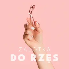 Dłoń trzyma zalotkę do rzęs. Czy zalotka niszczy rzęsy? Dowiedz się, jak jej używać, by ich nie uszkodzić.