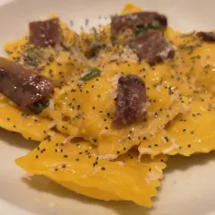 Ravioli gialli con acciughe e semi di papavero, un piatto da provare alla trattoria da me Bologna.