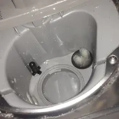 Wnętrze zmywarki Beko z błędem E01. Widoczny filtr i czujnik poziomu wody.