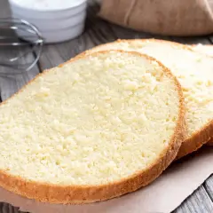 Puszysty biszkopt z 4 jaj z mąką ziemniaczaną, idealny do tortów. Obok jajka i składniki do wypieku.