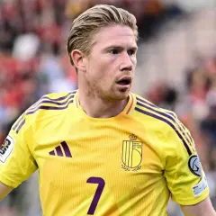 Kevin De Bruyne w żółtej koszulce reprezentacji Belgii, z numerem 7. Jego obecne drużyny to Manchester City i reprezentacja Belgii.