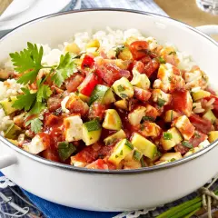 Eine köstliche zucchini-reis-pfanne einfach zubereitet mit viel Gemüse und Hähnchen. Frisch garniert mit Petersilie.