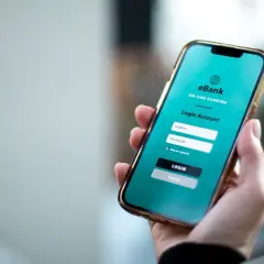 Dłoń trzyma smartfon z ekranem logowania do bankowości internetowej eBank. To wygodny sposób na przychodzące PKO BP.