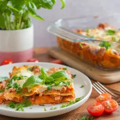 Pyszna lasagne na talerzu, z bazylią i pomidorkami. Idealnie, gdy zastanawiasz się, co podać do lasagne.