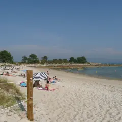 Gente disfrutando del sol en unas tranquilas playas nudistas Galicia, con arena dorada y aguas cristalinas.