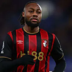Piłkarz w koszulce Bournemouth z numerem 38, z uwagą śledzi rozwój wydarzeń na boisku, jakby czekał na swoje okno transferowe.