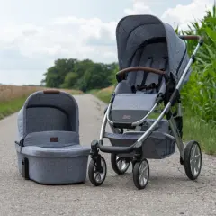 Grauer Kinderwagen mit passender Babywanne, Modell abc Salsa 4, steht auf einem Feldweg neben Maisfeld.