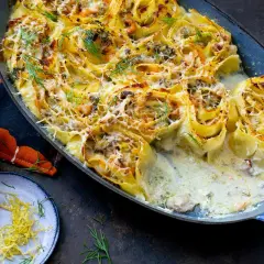 Lasagne roulées aux fruits de mer, gratinées et garnies d'aneth frais. Un délice crémeux à déguster.