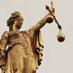 Złota statua Temidy z przepaską na oczach i wagą w dłoni, symbol sprawiedliwości, która może być utrudnianie korzystania z lokalu.