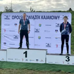 Trzech młodych mężczyzn na podium z medalami, na tle baneru Opolszczyzny.