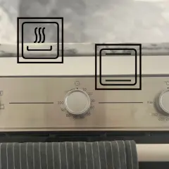 Bedienfeld eines Backofens mit Symbolen für Ober-/Unterhitze, Grillfunktion, Oberhitze und Umluft.