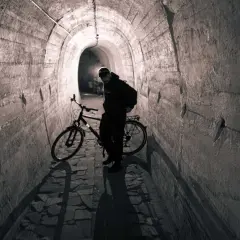 Mężczyzna z rowerem w tunelu. To może być początek jego przygody na podziemnej trasie rowerowej.