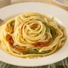 Un piatto di spaghetti conditi con delicati fiori di zucca, un classico della cucina italiana.