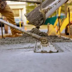 Wylewanie i wyrównywanie świeżego betonu na budowie.