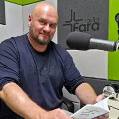 Arkadiusz Łodziewski w studiu Radia Fara, trzymający książkę. Jego życiorys mógłby opowiadać o tej chwili.