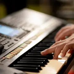 Dłonie grające na keyboardzie, tworząc muzykę. To jest keyboard.