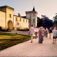 Un groupe de personnes se promène sur le chemin menant au **château Toulouse Lautrec** au coucher du soleil.