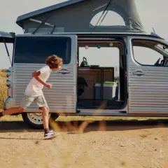 Dzieci biegną do swojego kampera Citroen, gotowe na przygodę nad morzem.