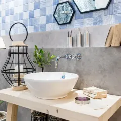 Bad Deko Ideen: Waschbecken mit Kaktus, Laterne und Büchern. Blaue Fliesen und Betonwand.