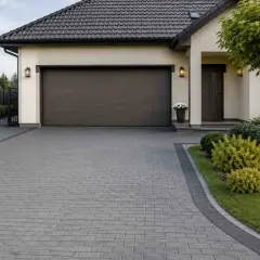 Elegancki podjazd z płyt ażurowych prowadzi do nowoczesnego domu z garażem.