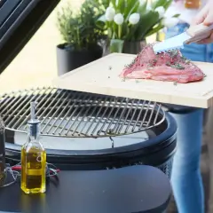 Préparation d'un morceau de bœuf Black Angus assaisonné, prêt à être grillé sur un barbecue. Huile d'olive et épices à proximité.