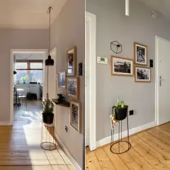Flur mit Holzboden und grau gestrichenem Wanddesign. Bildergalerie und Pflanzen zieren die Wände.