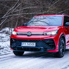 Czerwony Volkswagen Tiguan na śnieżnej drodze. Wiele osób szuka **volkswagen tiguan opinie** przed zakupem.