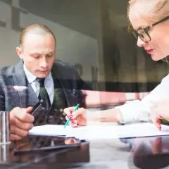 Radca prawny i prawnik analizują dokumenty przy biurku.