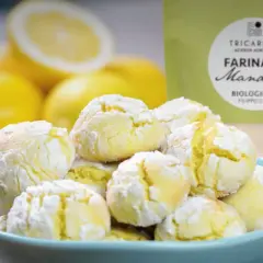 Biscotti con farina di mandorle, morbidi e profumati, accanto a limoni freschi e una confezione di farina.