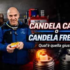 Un uomo sorride in un negozio di ricambi, tenendo una scatola di candele. Davanti a lui, una candela calda e una fredda.