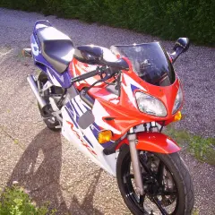 Sportowy motocykl Honda NSR 125 w czerwono-biało-niebieskich barwach, idealny do poznawania jego danych technicznych.