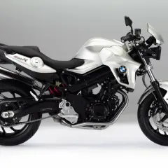 Srebrny motocykl BMW 800R z czarnym siedzeniem i detalami, prezentujący sportowy design i moc.