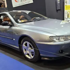 Elegancki, srebrny Peugeot 406 coupe z brązową tapicerką, prezentowany na wystawie.