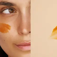 Un masque visage orangé appliqué sur la joue d'une femme. La question est : combien de temps garder un masque visage pour un soin optimal ?