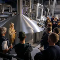 Visite Goudale : un groupe découvre les cuves de brassage. Une guide explique le processus de fabrication de la bière.