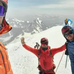 Trzech alpinistów na szczycie Mont Blanc cieszy się widokiem.