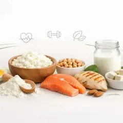 Różnorodne źródła, które pokazują, proteiny co to: ryba, kurczak, jajko, nabiał, ciecierzyca, migdały, szpinak i białko w proszku.