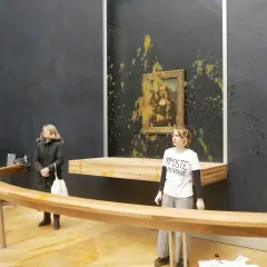 Obraz pokazuje, gdzie znajduje się Mona Lisa, w Luwrze, z żółtą substancją rozbryzganą na ścianie i obrazie.