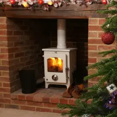 Installation d'un poêle à granulés avec conduit existant dans une cheminée en briques, décorée pour Noël.