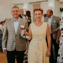 Elegancka sukienka dla mamy panny młodej plus size w kolorze pastelowej żółci, ozdobiona delikatnymi kwiatowymi aplikacjami.