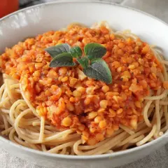 Herzhafte Linsen Bolognese auf Spaghetti, garniert mit frischen Kräutern. Ein köstliches vegetarisches Gericht.